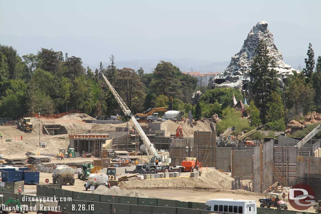 8.26.16 - On the far hill, the old Skyway hill, they are working on placing more i-beams.  In the mid-ground you can see a bridge/tunnel taking shape.  On the right are retaining walls for the river and backstage marina for Fantasmic as well as the support structure for the rockwork and waterfalls.