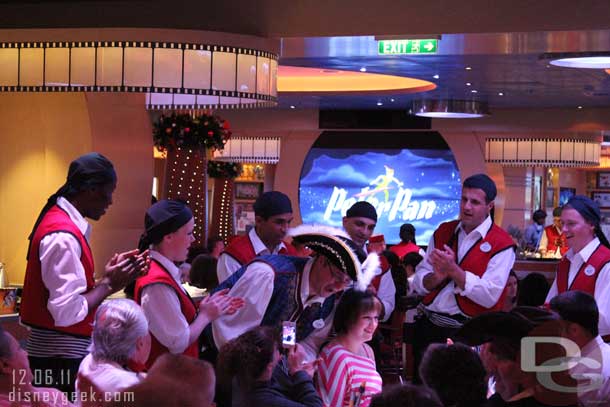 The wait staff gathered around a table to sing happy birthday.