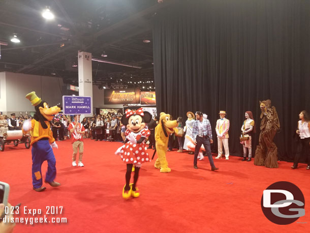 Goofy, Minnie, Donald, and Pluto are close behind the band.