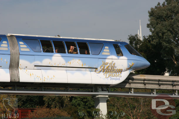 A monorail going by (its weird that they are both wrapped the same to me)