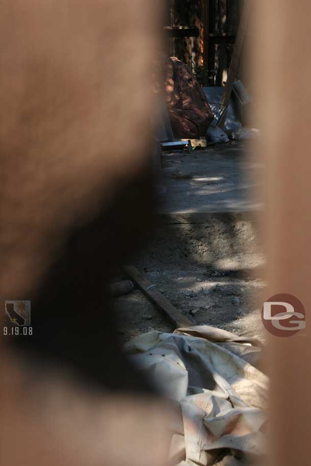 Through a crack in the fence, shows there is nothing left.