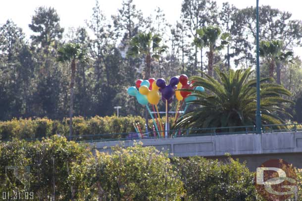 They are installing celebration decorations at the parking structure entrance signs.