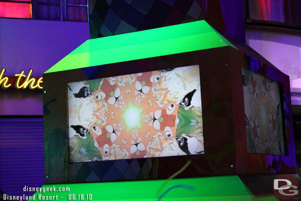 The screens show a mix of Disney and abstract film.