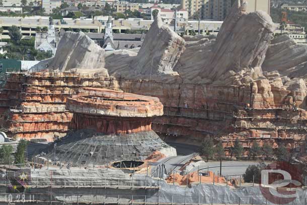 The wide shot reveals where they are on the scaffolding removal.