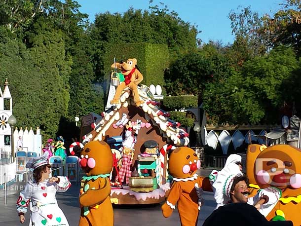 Pluto atop the gingerbread house with Goofy, replacing Max who is no longer in the parade.