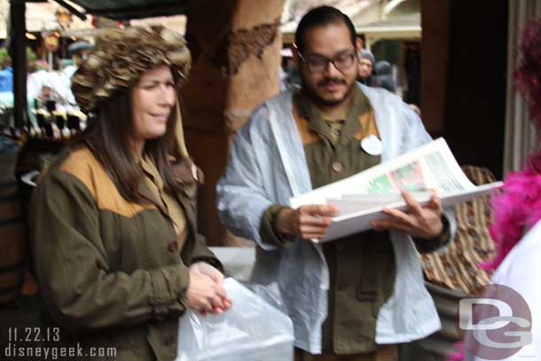 Oops..  hard to hold the camera steady and an umbrella.. but here are two cast members passing out Jingle Cruise posters near the exit to the attraction.