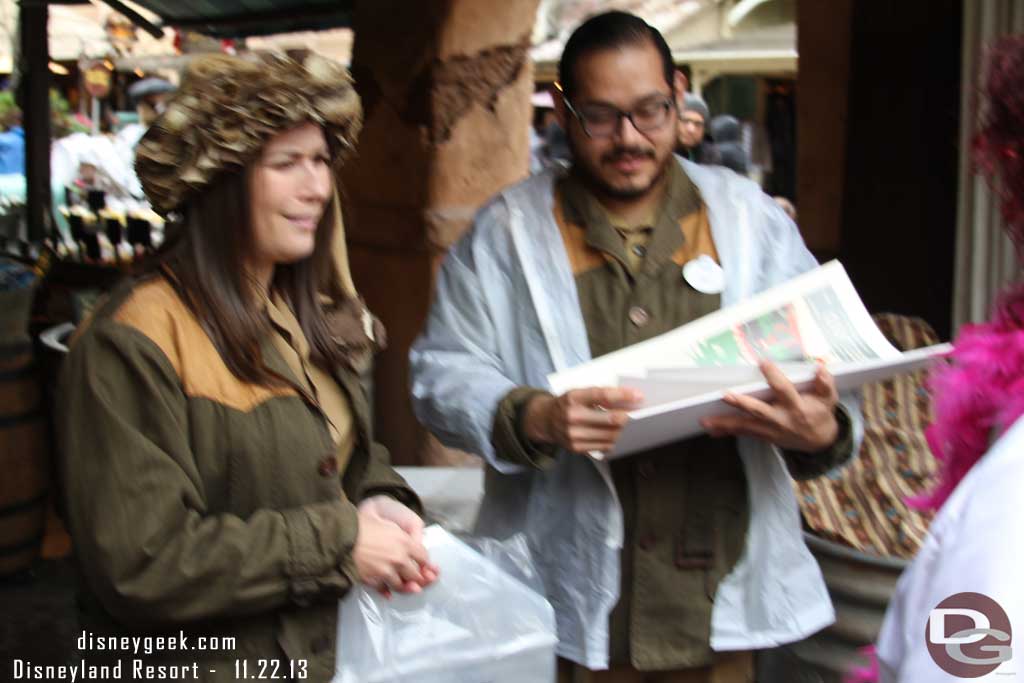 Oops..  hard to hold the camera steady and an umbrella.. but here are two cast members passing out Jingle Cruise posters near the exit to the attraction.