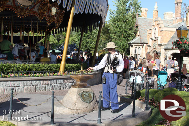 A photo pass photographer hanging out by the Sword in the Stone waiting for guests to give it a try.