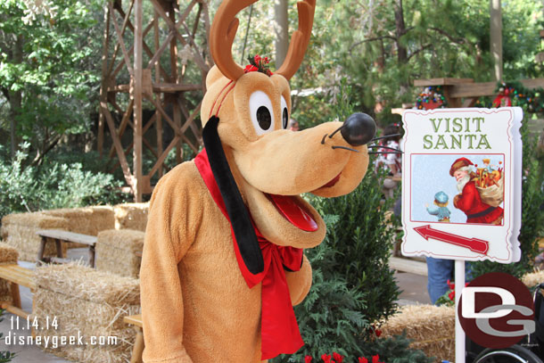 Pluto helping to direct guests to Santa.