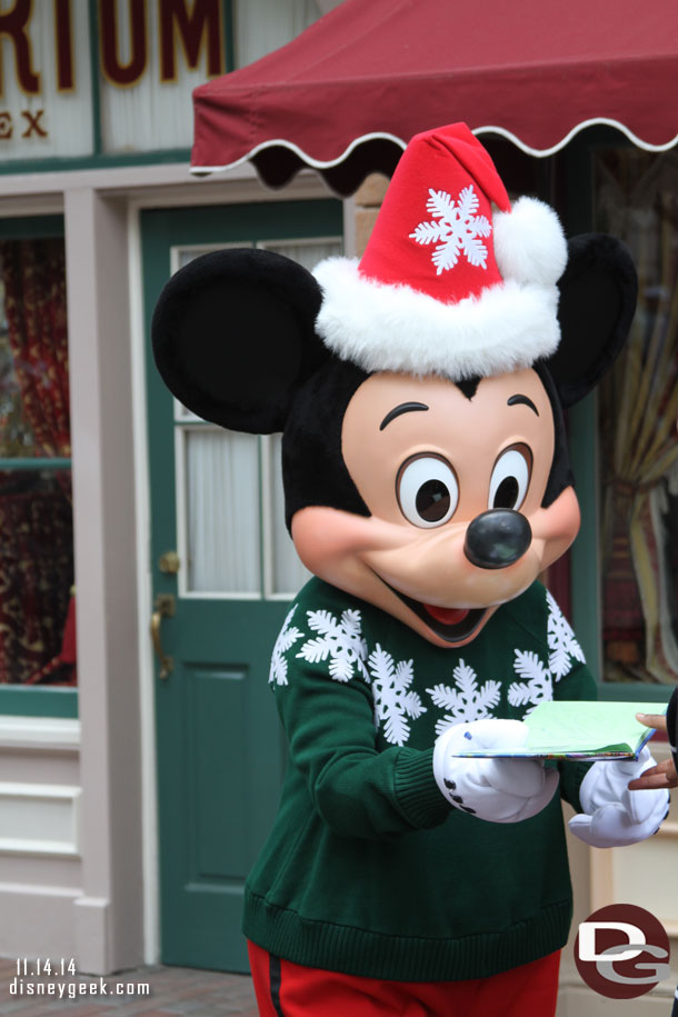 Mickey signing autographs in Town Square in his holiday sweater.