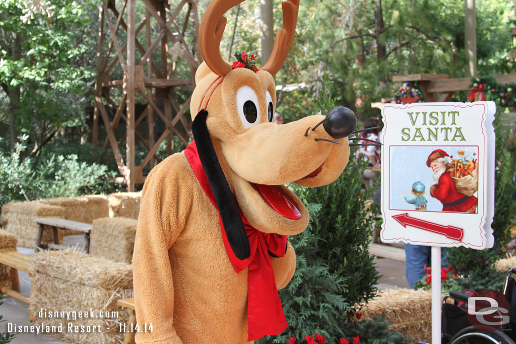 Pluto helping to direct guests to Santa.