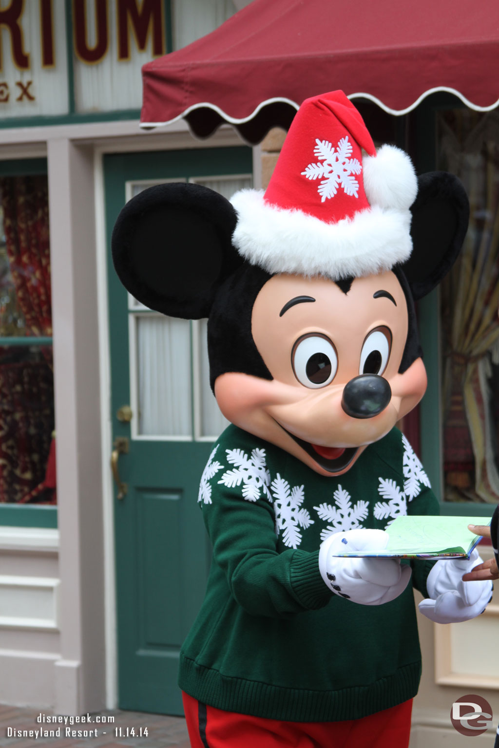 Mickey signing autographs in Town Square in his holiday sweater.