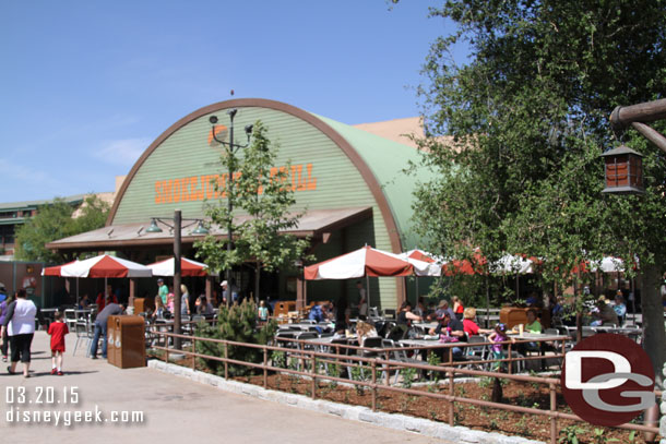 The outdoor dining area features some trees, fresh mulch/bark in the planters and a national parks feel.