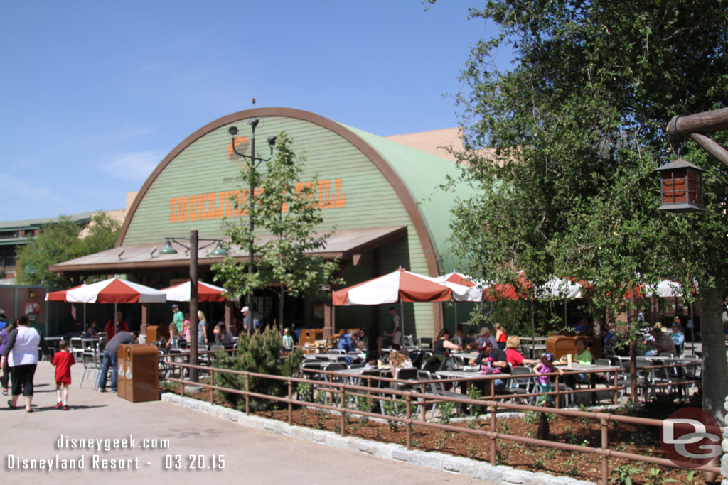 The outdoor dining area features some trees, fresh mulch/bark in the planters and a national parks feel.