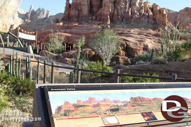 Lightning McQueen is in Ornament Valley watching the Racers go by.