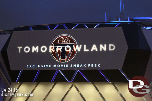 The Tomorrowland Sneak Peek sign at night.