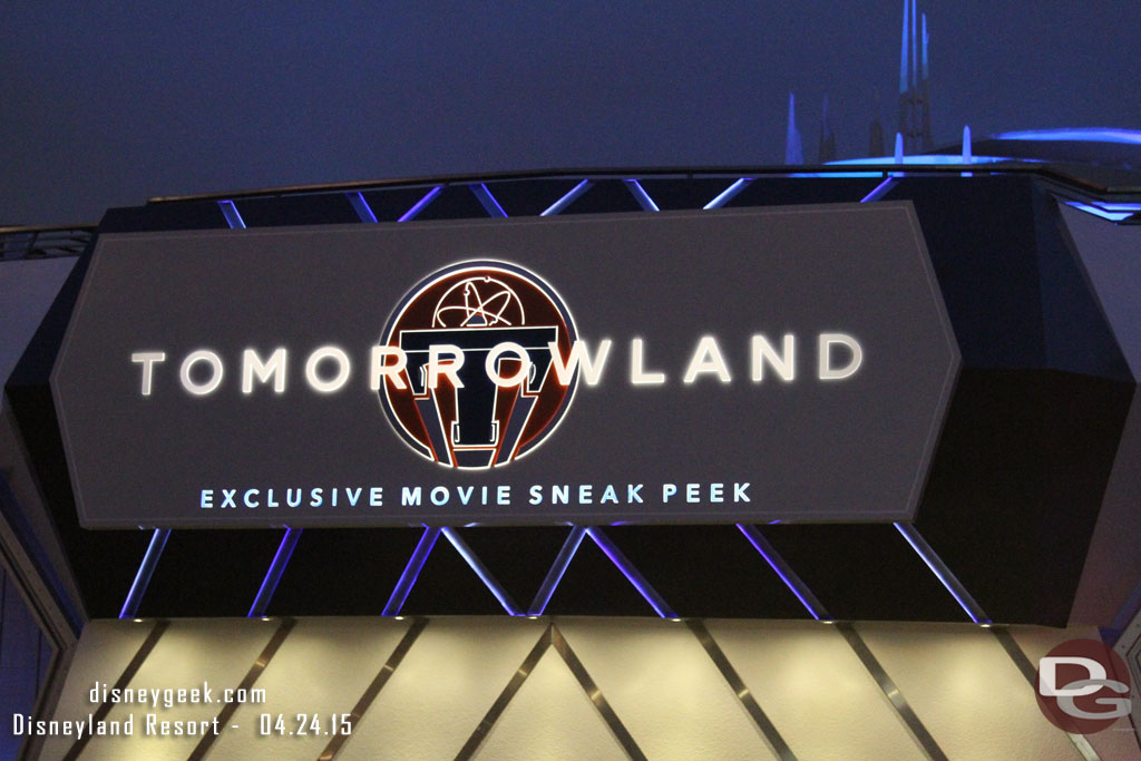 The Tomorrowland Sneak Peek sign at night.