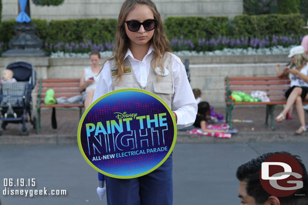 Photo Pass cast members walking the parade route with signs you can have your picture taken with.