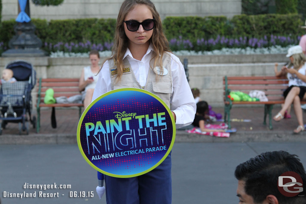 Photo Pass cast members walking the parade route with signs you can have your picture taken with.