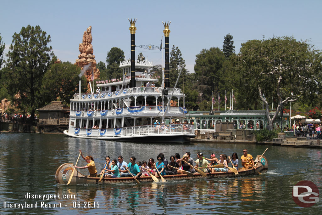 A canoe passing by and the Mark Twain preparing to cast off on the Rivers of America.  