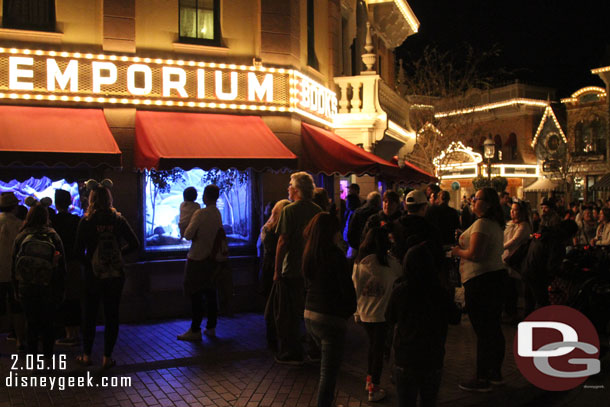 A healthy/steady crowd of guests looking at the Emporium windows.