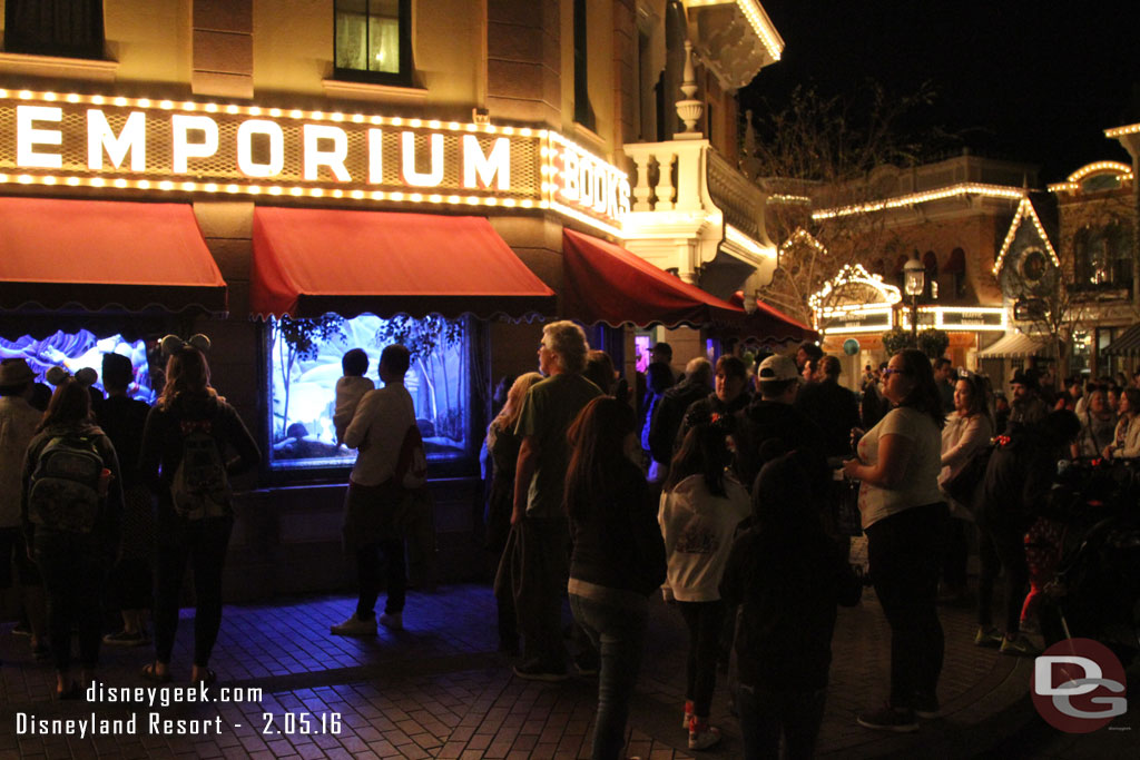 A healthy/steady crowd of guests looking at the Emporium windows.