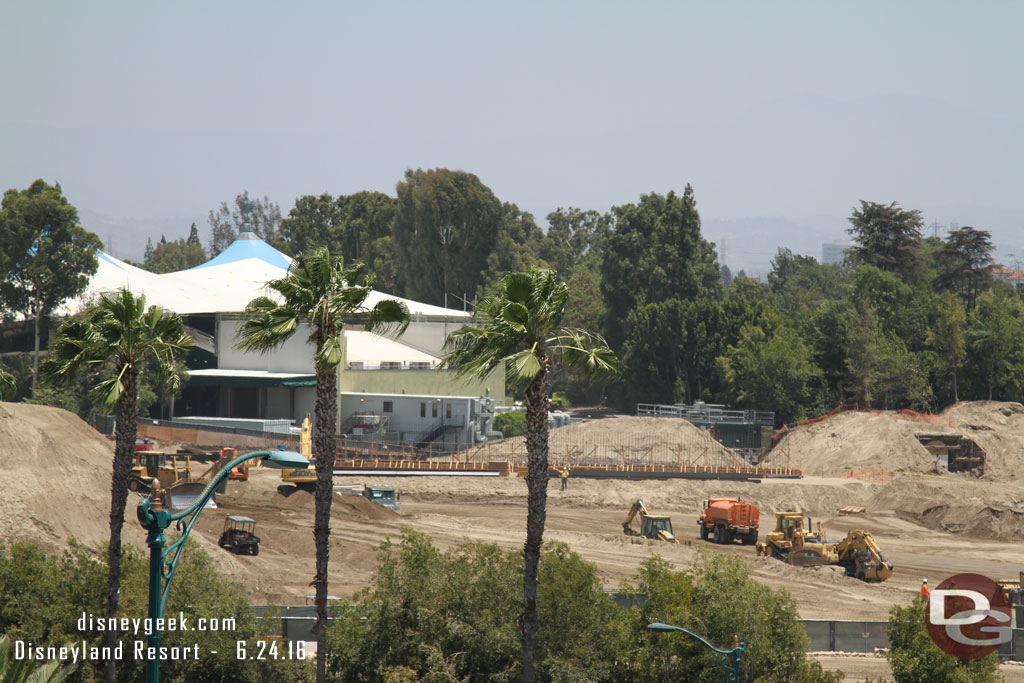 Trucks are still hauling away dirt.   In the distance the foundation for something appears to be taking shape.