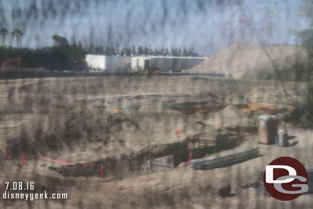 Through the fence you can see where they are laying pipes and conduit.  In the middle of the shot appears to be forms for a footer going in.