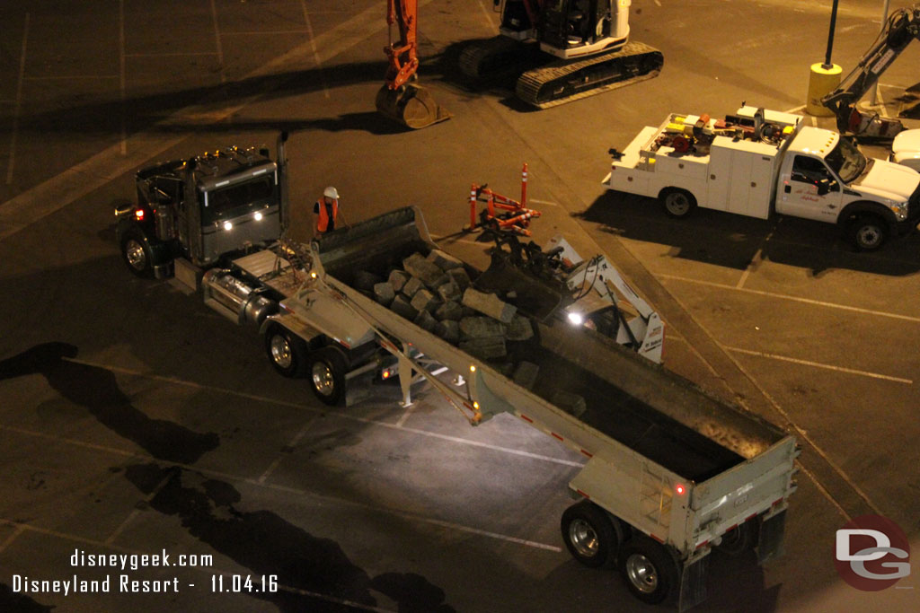 A small bobcat loading concrete pieces from the parking structure.