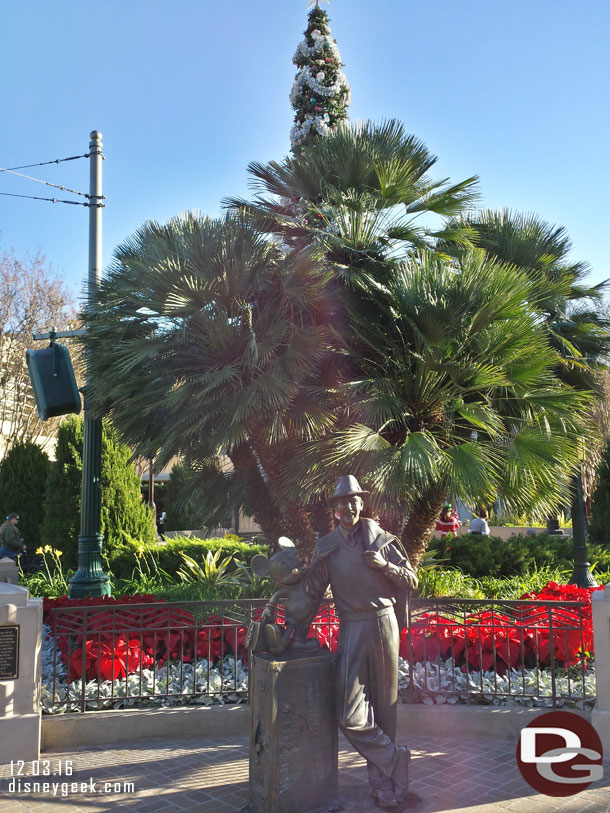 Storytellers Statue with the Christmas tree beyond it.