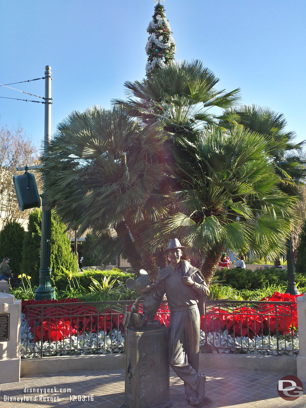 Storytellers Statue with the Christmas tree beyond it.