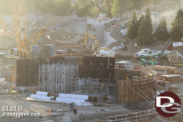 Scaffolding rising up from the basement of the circular structure.  Looks to be supports for the second floor.  Interesting those are going up before the exterior walls are poured.