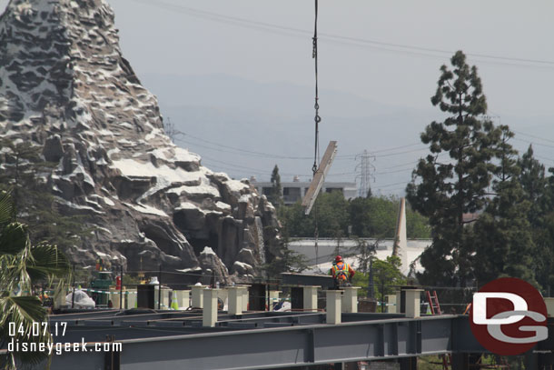 An i-beam being lowered into place on the roof.