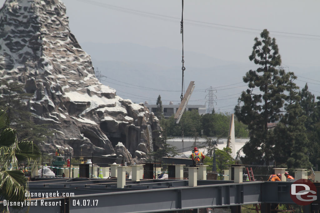 An i-beam being lowered into place on the roof.