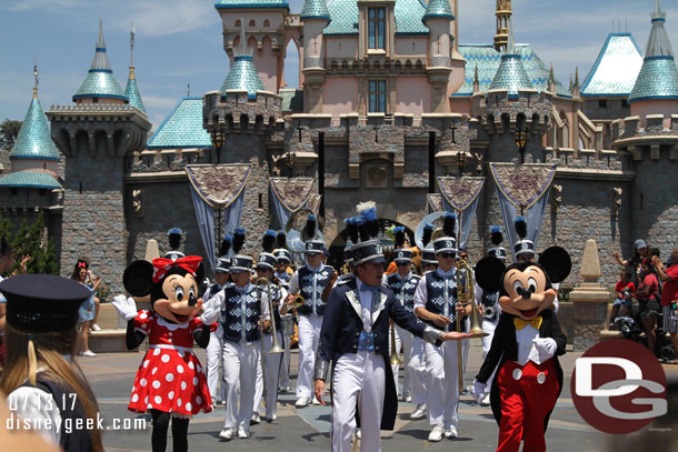 The band and characters march up Main Street USA  to Town Square