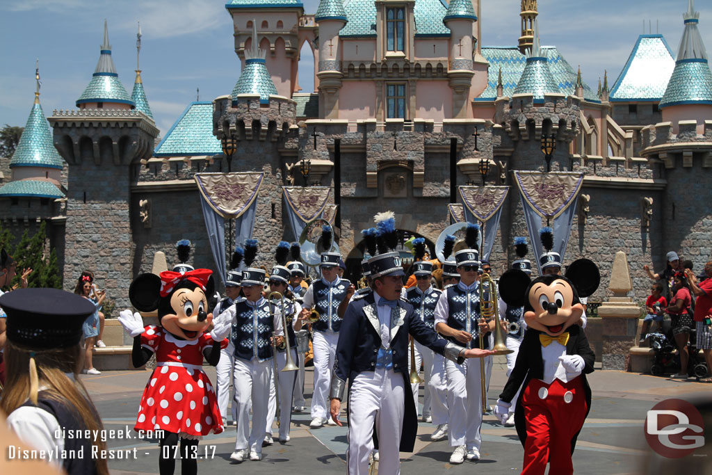 The band and characters march up Main Street USA  to Town Square