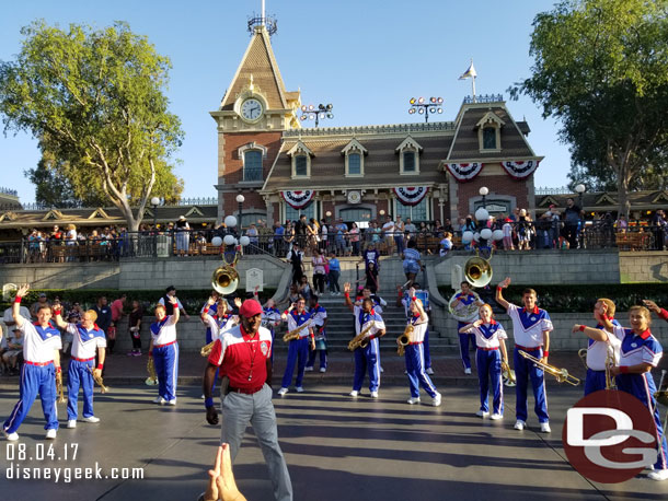 The Disneyland 2017 All-American College Band performing in Town Square.   Notice the train line behind them filling the platform level and coming down the steps.