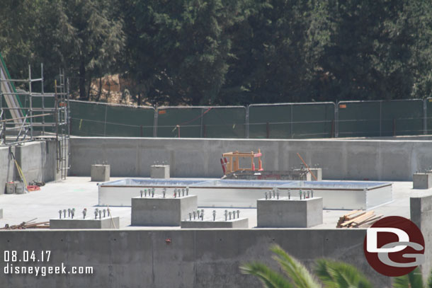 A closer look at the roof of the concrete building on the right.  Assuming those are for steel to be connected to support the facade mountains.