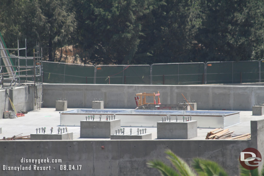 A closer look at the roof of the concrete building on the right.  Assuming those are for steel to be connected to support the facade mountains.