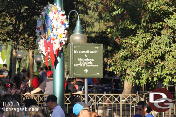 A sign up in the small world mall pointing out where FastPass distribution is.