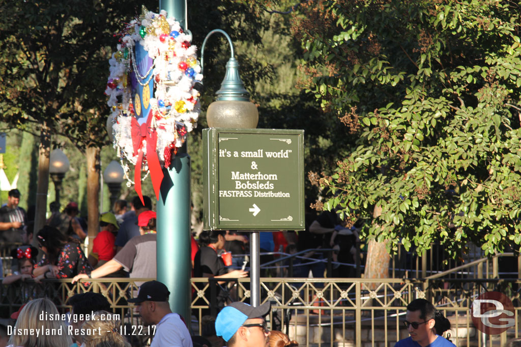 A sign up in the small world mall pointing out where FastPass distribution is.