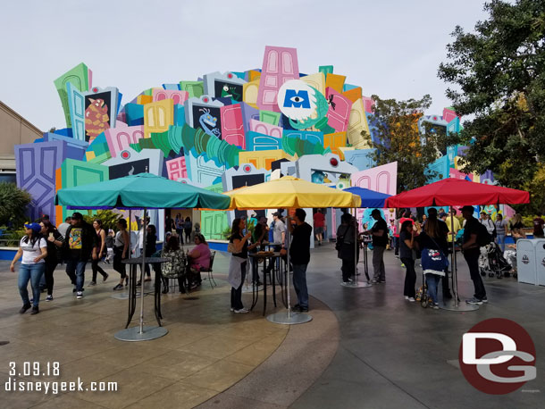 Tables and umbrellas set up near a marketplace in the Backlot.