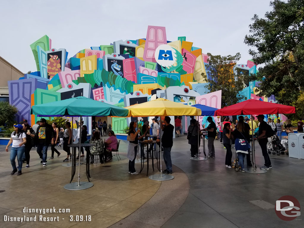 Tables and umbrellas set up near a marketplace in the Backlot.