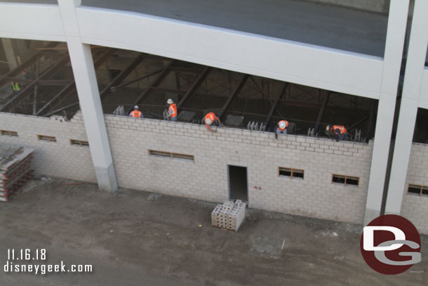 Down below more bricks being added to what appears to be some sort of room (maybe storage or office space) on the ground level of the structure under the ramp.