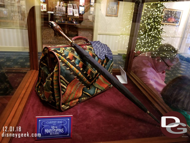 More props from Mary Poppins Returns in another display case - The Carpet Bag, Umbrella and gloves