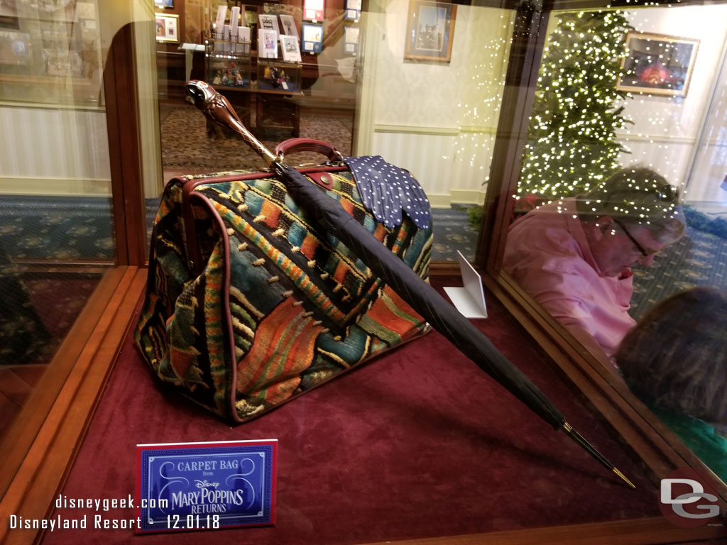 More props from Mary Poppins Returns in another display case - The Carpet Bag, Umbrella and gloves