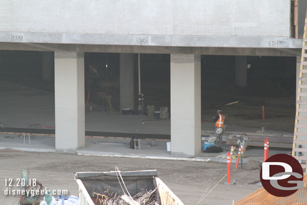 Teams working on the first floor.  Hard to tell what is going on. But you can see there is still some dirt where the first floor has not been poured.  Also it appears a newer strip of concrete has been poured just inside.