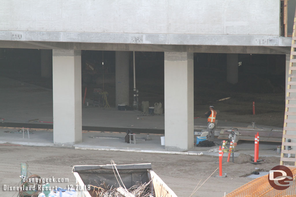 Teams working on the first floor.  Hard to tell what is going on. But you can see there is still some dirt where the first floor has not been poured.  Also it appears a newer strip of concrete has been poured just inside.