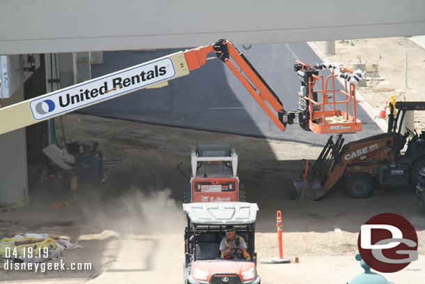 Blacktop has been laid on the driveway between the two structures.