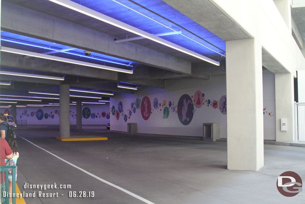 The far wall features bubbles with characters in them.  There are two driveways so trams can pass and in the far left is the Mickey Van load/unload area and some space for other Disney vehicles.